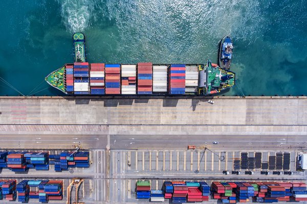 A container ship tied at a dock covered with shipping containers.