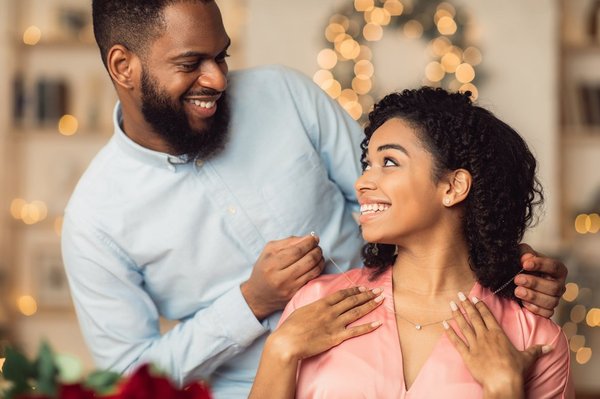 Someone is receiving a gift of jewelry from another person.